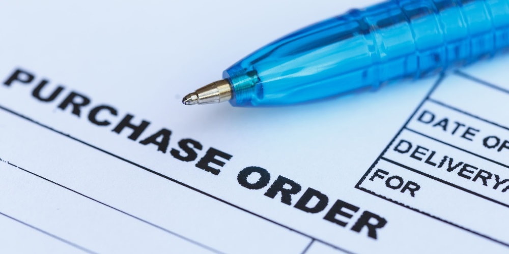 Image of the top of a purchase order with a blue pen lying across it