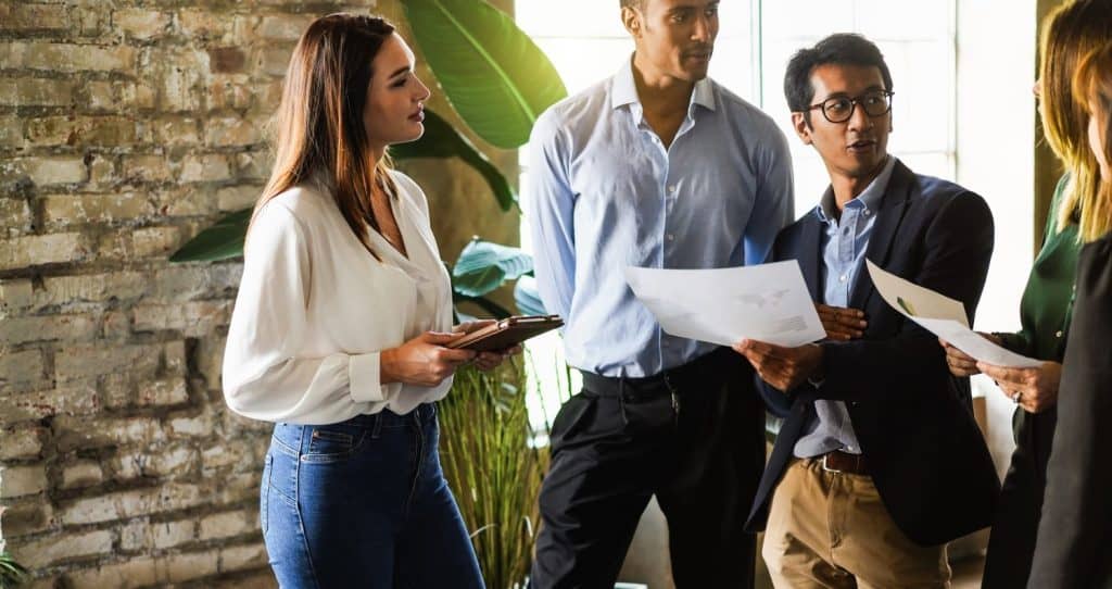 Multiracial colleagues working inside business office discussing about financial projects - Teamwork planning new strategies - Main focus on asian man face