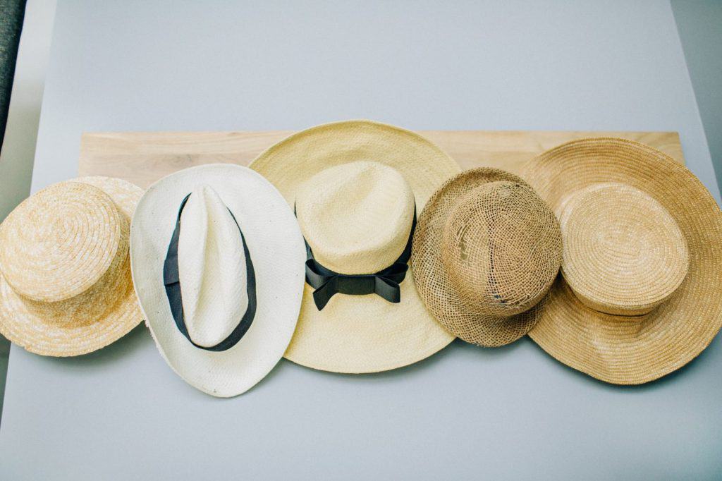 Straw hats collection on pastel blue background.