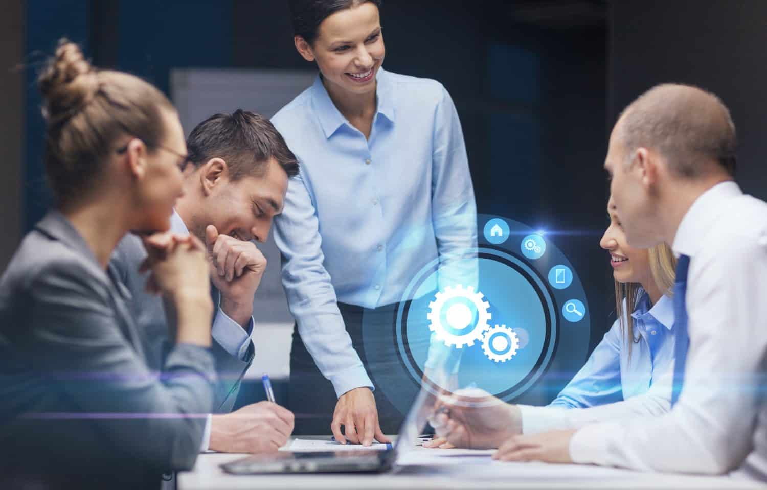 business, technology, deadline, management and people concept - smiling female boss talking to business team in office late night