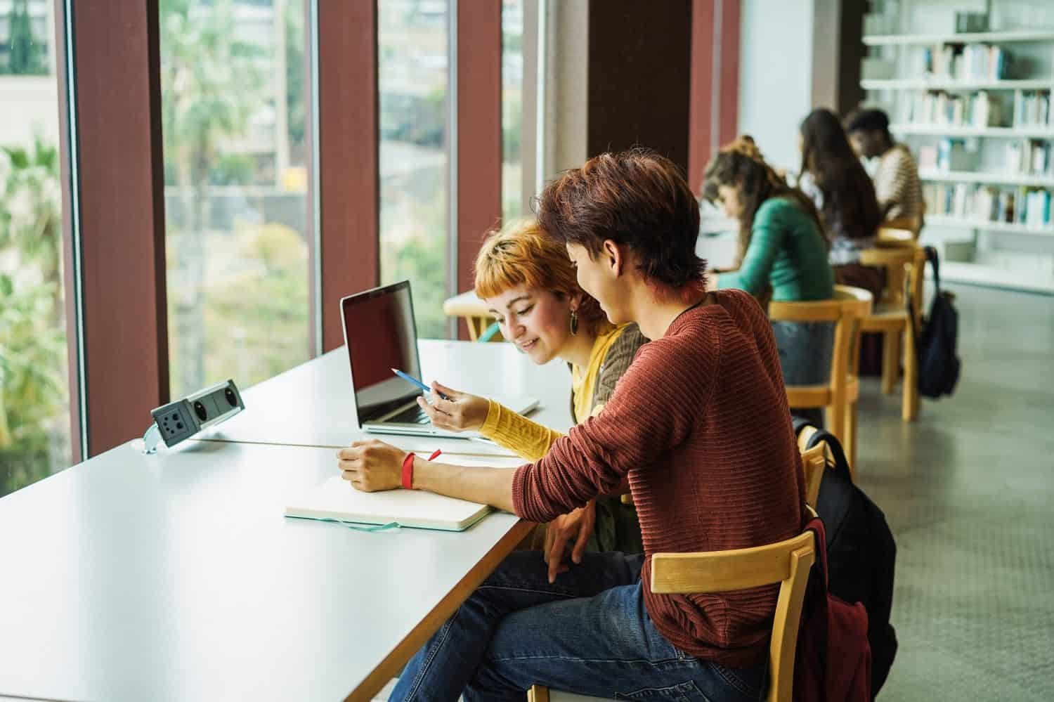 Young group of people studying inside college university library - Back to school and education concept -  Focus on student man head