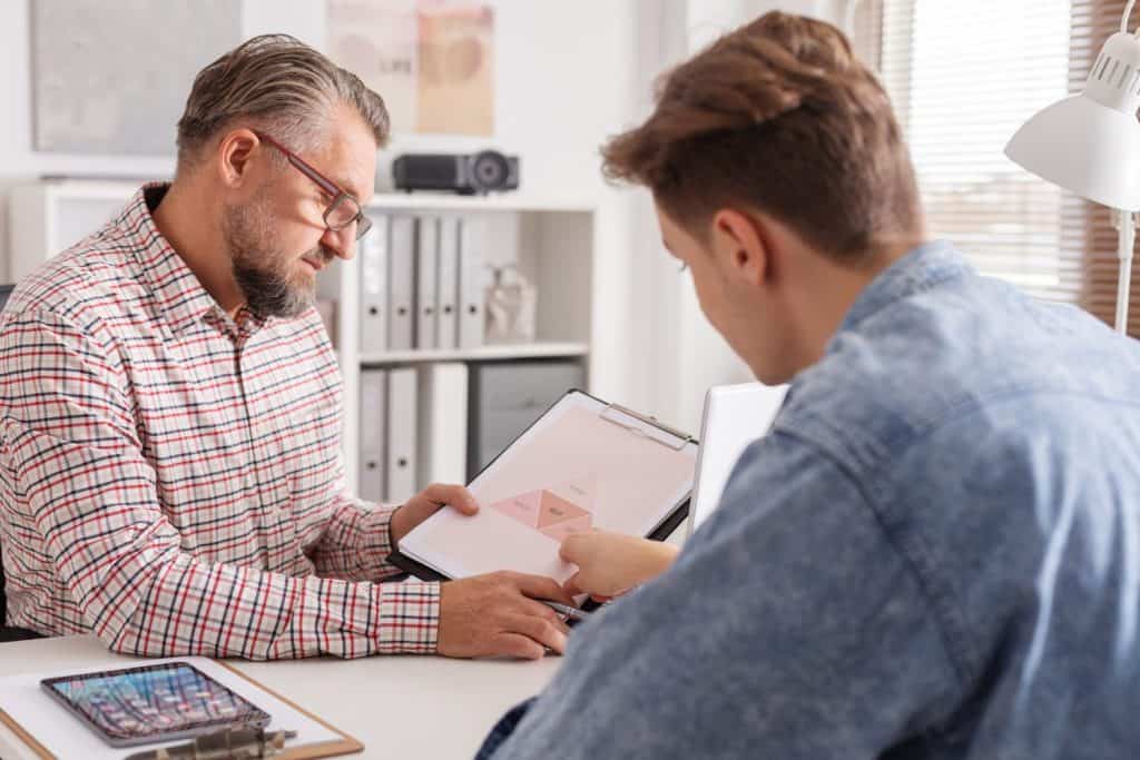 Senior account manager and young man during job interview in small firm