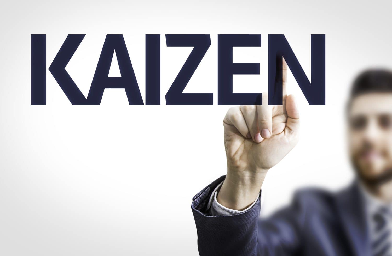 Business man pointing to transparent board with text: Kaizen