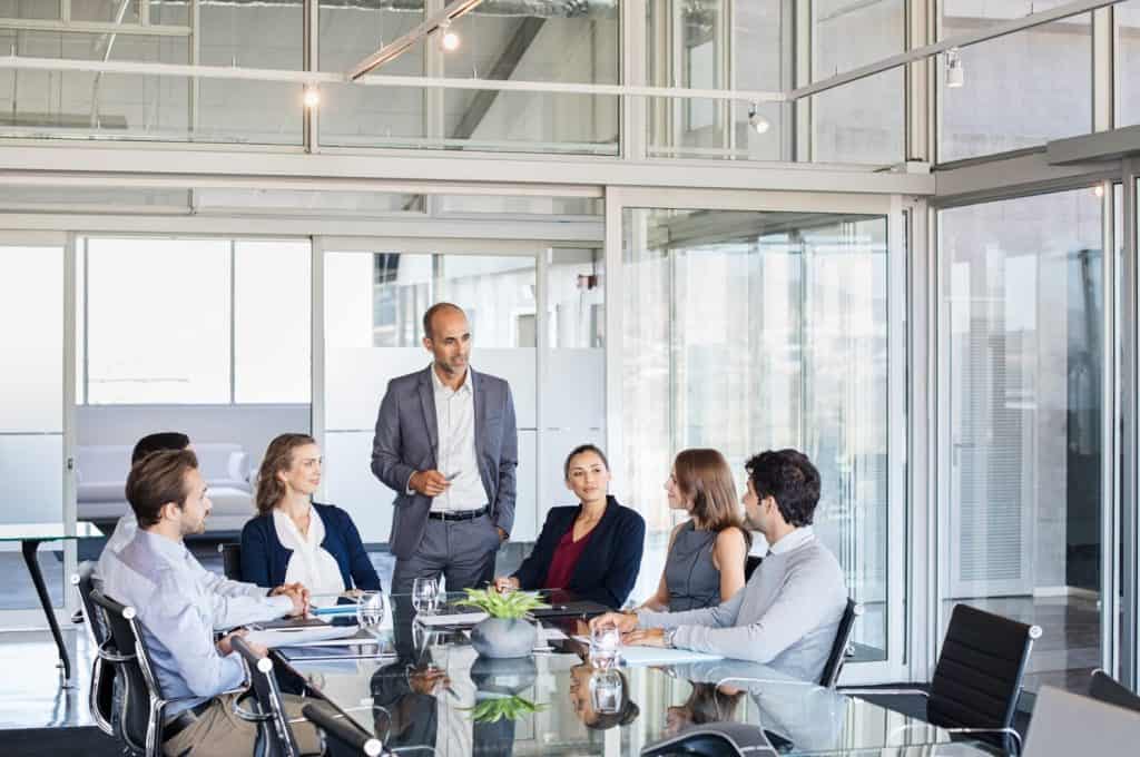 Human resource manager training people about company and future prospects. Group of businesspeople sitting in meeting room and listening to the speaker. Leader man and work group in a conference room.