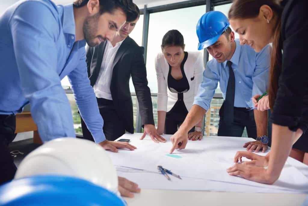 business people group on meeting and presentation in bright modern office with construction engineer architect and worker looking building model and blueprint planbleprint plans